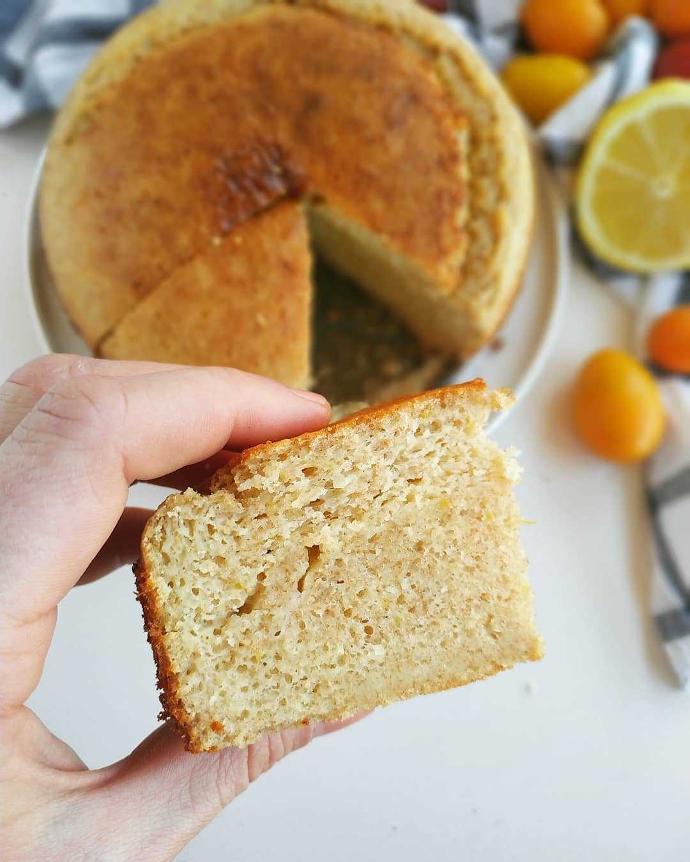 Se vería una porción de bizcocho de limon sin gluten, con unos limones de fondo Bizcocho sin gluten y sin azucar, con sabor de limón