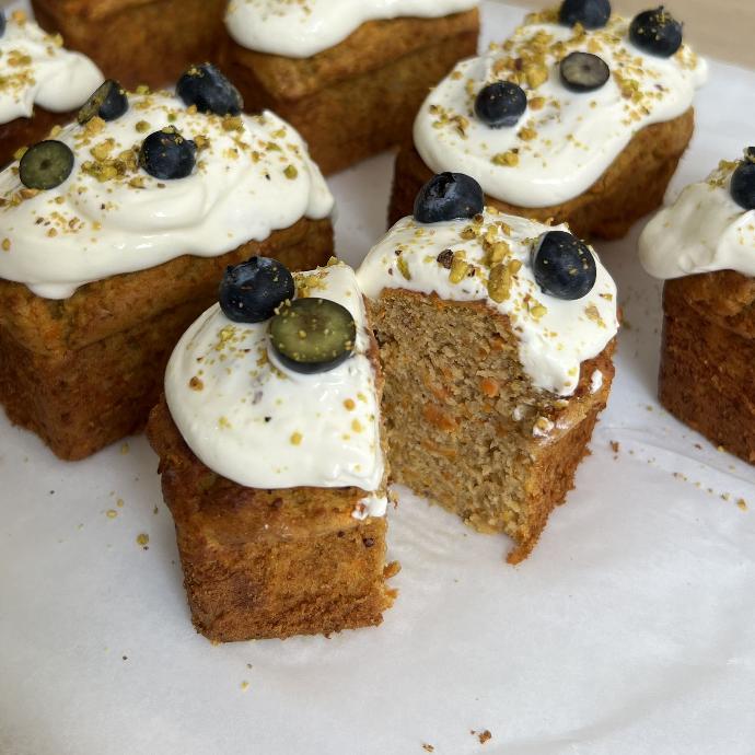 Carrot Cake Sin Azúcar con Crema y Arándanos Porciones de carrot cake sin azúcar decoradas con crema y arándanos frescos.